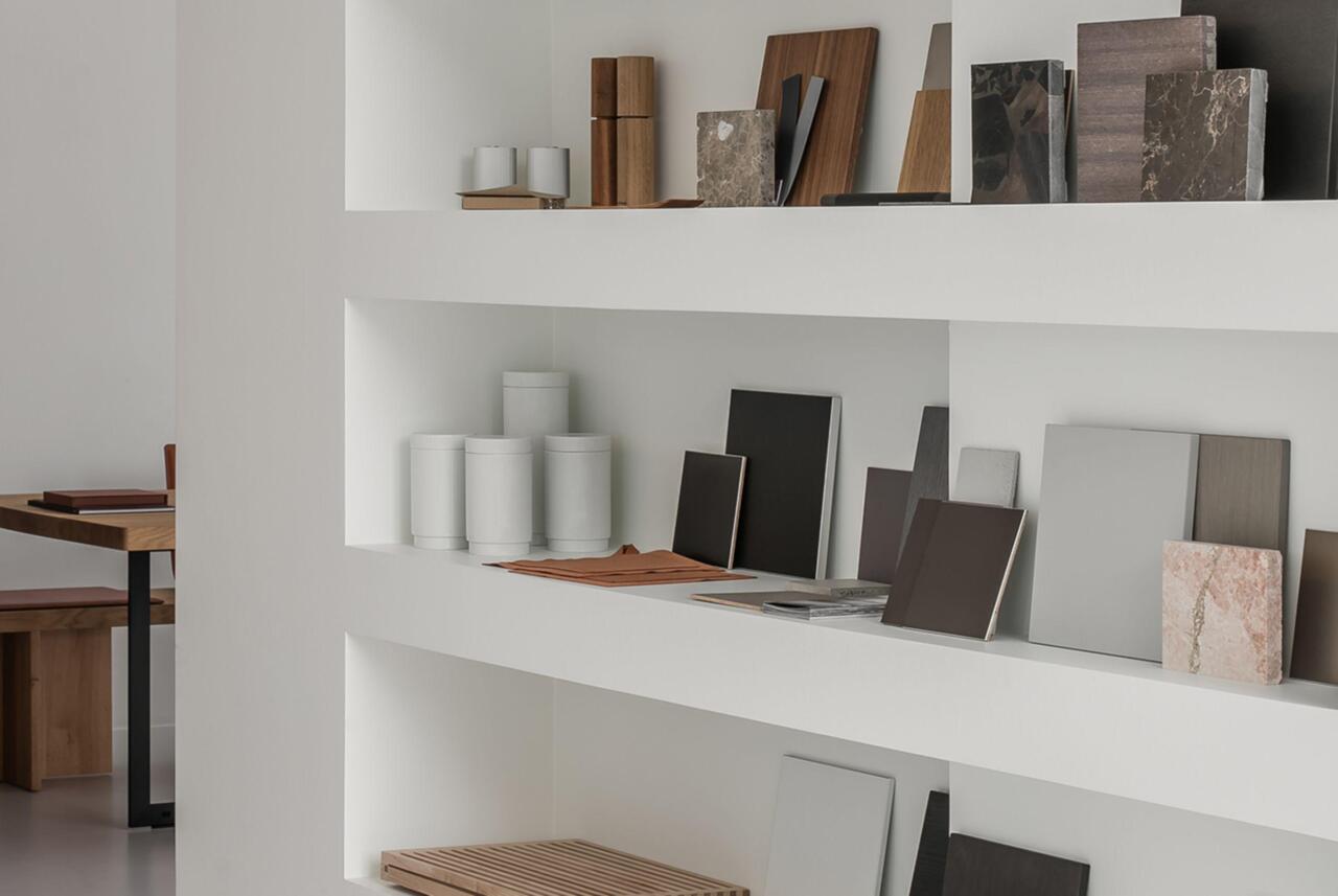Detail van een nis in een witte muur in een showroom, gevuld met stalen voor het maken van een keuze voor de keuken.
